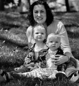 Cathleen Peter with her daughters sitting in the grass