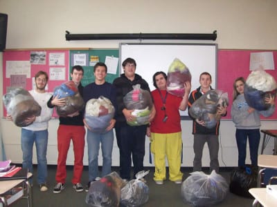 Members of the Jr. Sr. HS Club holding collected coats