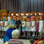 Kindergarteners wearing caps on stage