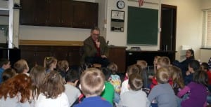 Photo of guest poet Tom Lee sharing a story with elementary students