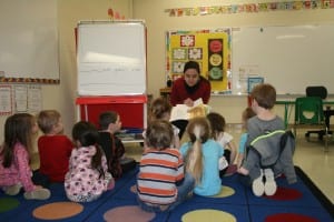 Pre-K students are read aloud "The Grouchy Lady Bug" by Eric Carle