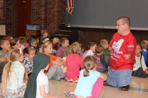 John Robinson speaks among elementary students