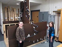 Students stand with marble rollercoaster