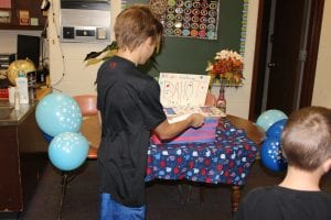 5th grade student putting ballots in the vote box