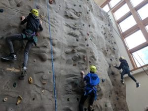 students climbing rock wall